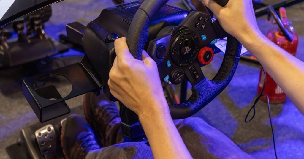 Man immersed in virtual racing game using realistic simulator setup with steering wheel and pedals.