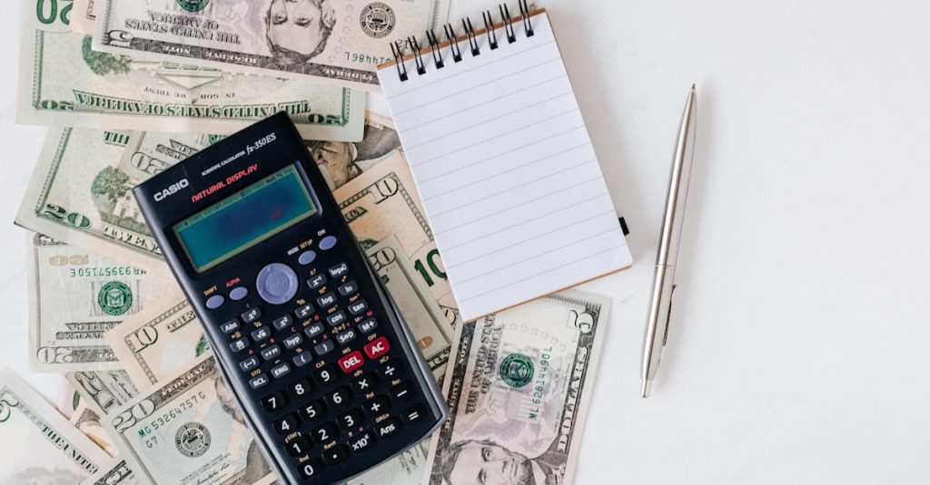 Flat lay of US dollar bills with calculator and notebook for budgeting.